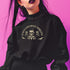 A Christmas sweatshirt with "SEASONS SCREAMINGS, DARKLING" text arched over a skull wearing Santa hat. Bats, flowers, and ornate designs surround the skull in vintage-inspired style.